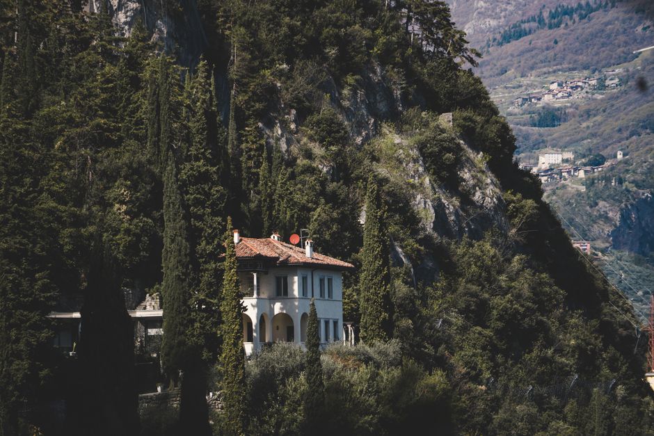 Idyllic villa nestled among towering mountains and dense forest, offering tranquil solitude.