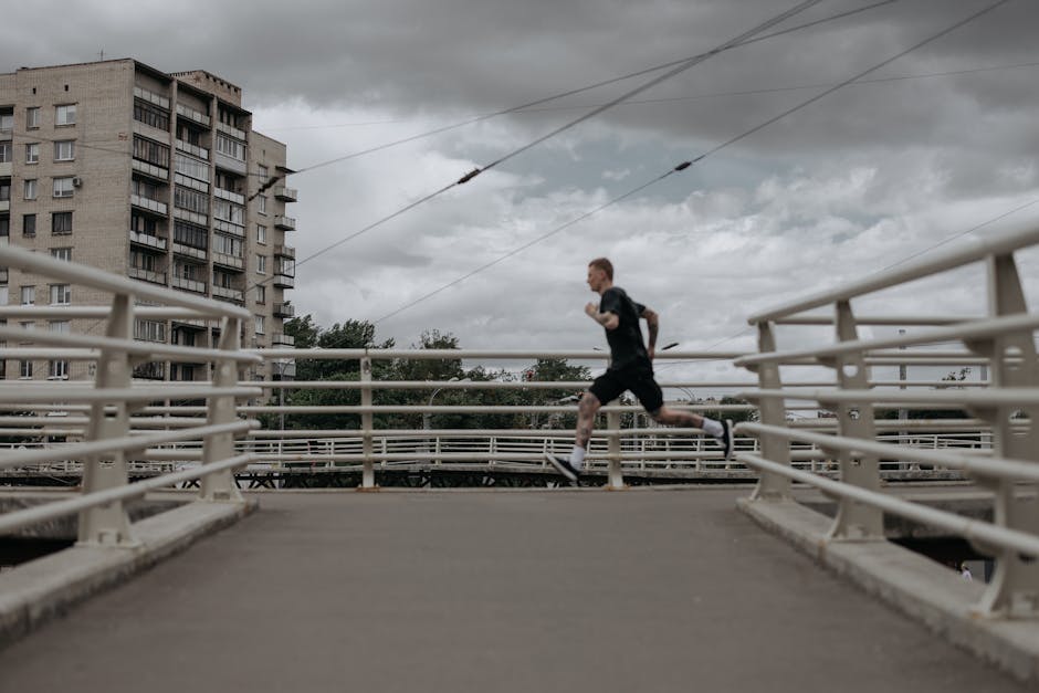 A man runs on a city bridge under cloudy skies, showcasing an active lifestyle.