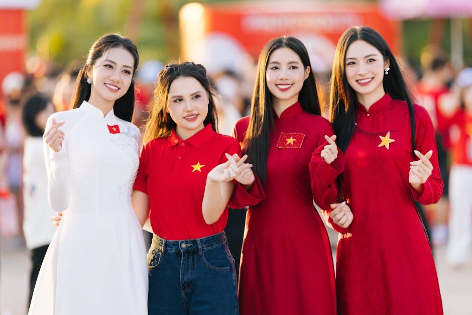 Four women in traditional and modern outfits celebrating outdoors during the day.