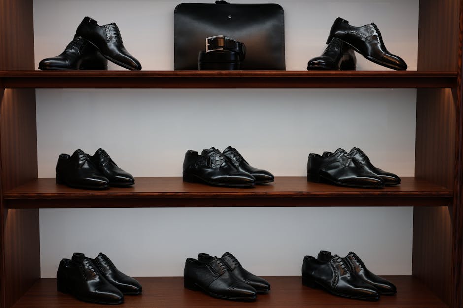 A stylish display of black leather shoes and accessories on wooden shelves in a store.
