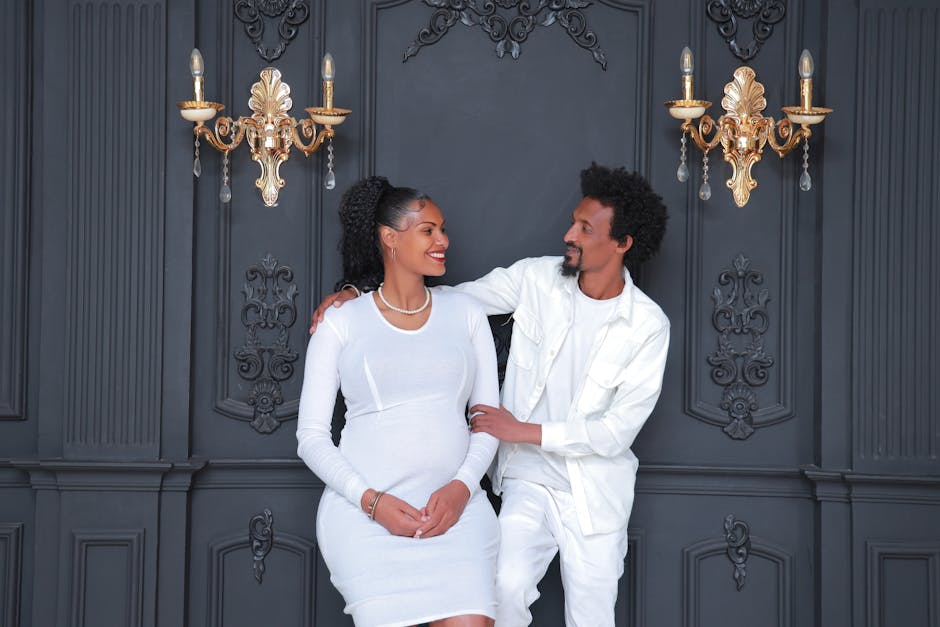 A joyful couple celebrating pregnancy in an elegant indoor setting with classic decor.