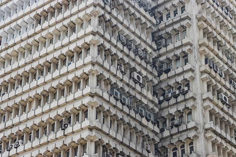 Detailed view of an abstract brutalist building facade in New Delhi, showcasing architectural symmetry and aesthetic appeal.