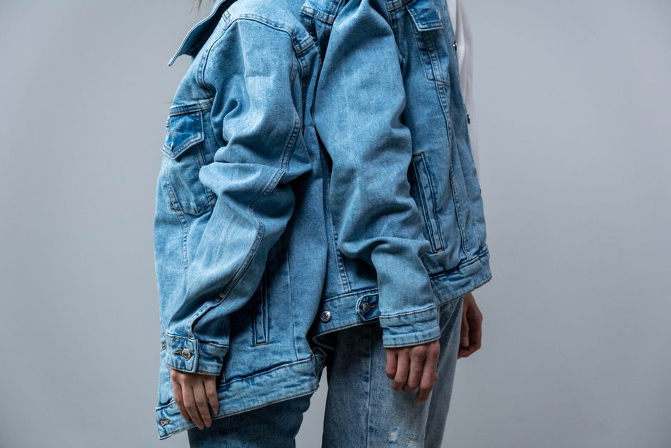 Fashionable denim outfit featuring jean jacket and jeans in studio shot.