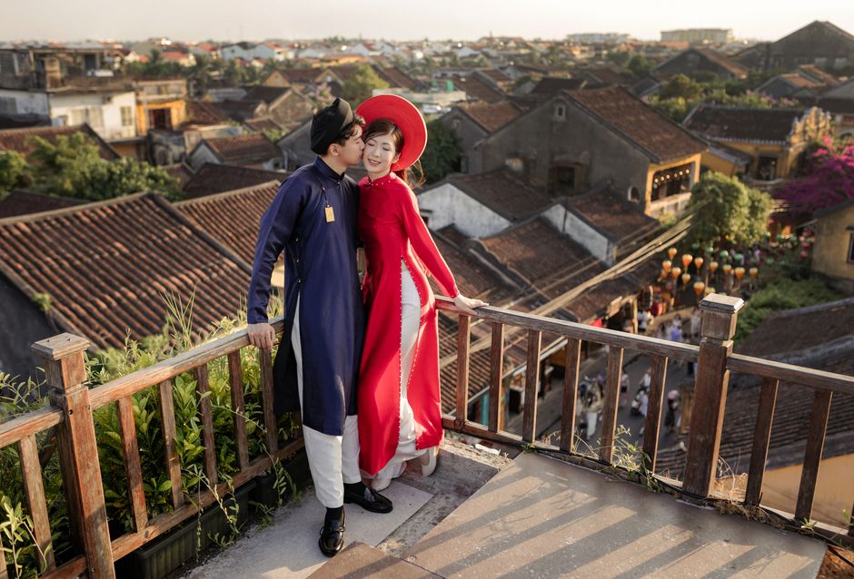 A couple in Vietnamese traditional attire enjoying a scenic view in Đà Nẵng, Việt Nam at sunset.